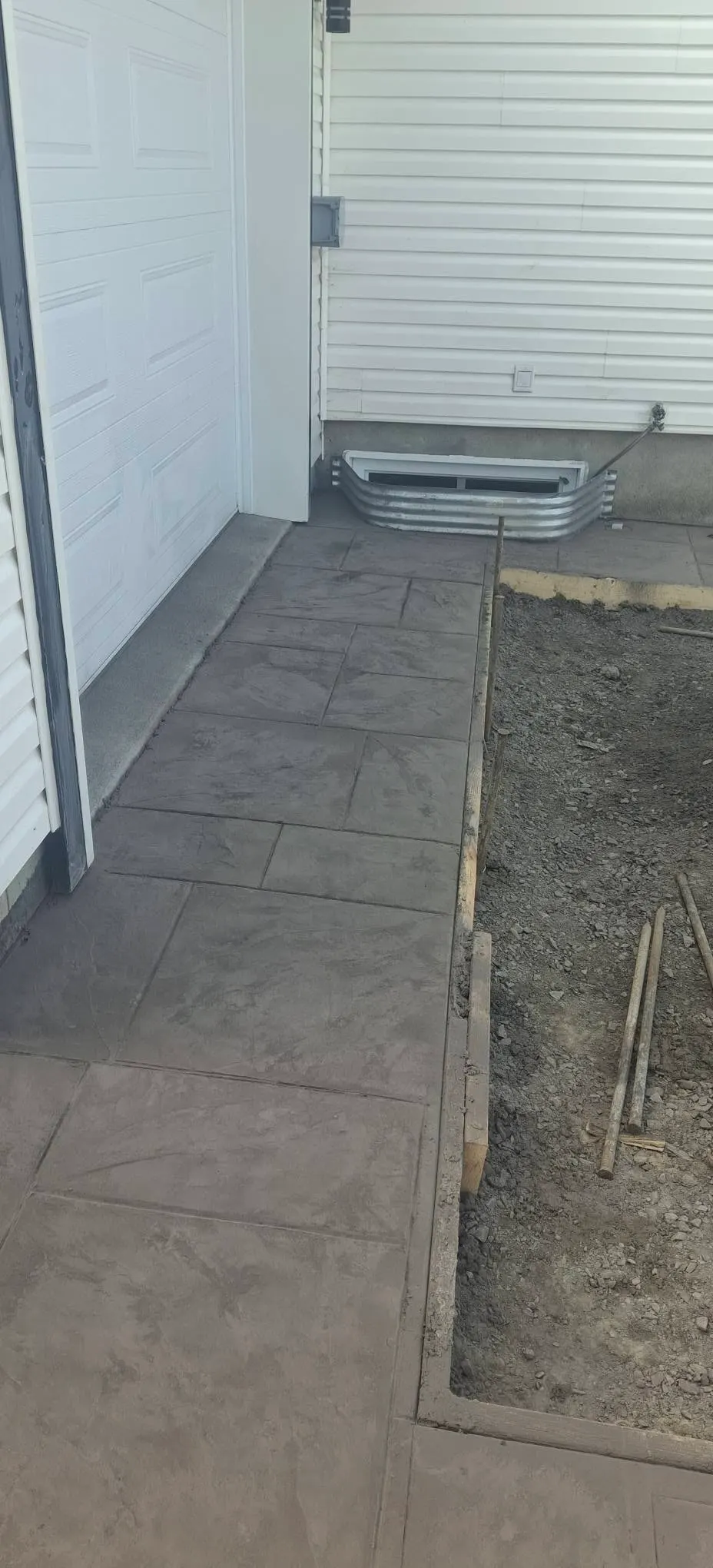 Trottoir estampé le long de la maison, ouvrage terminé : béton estampé