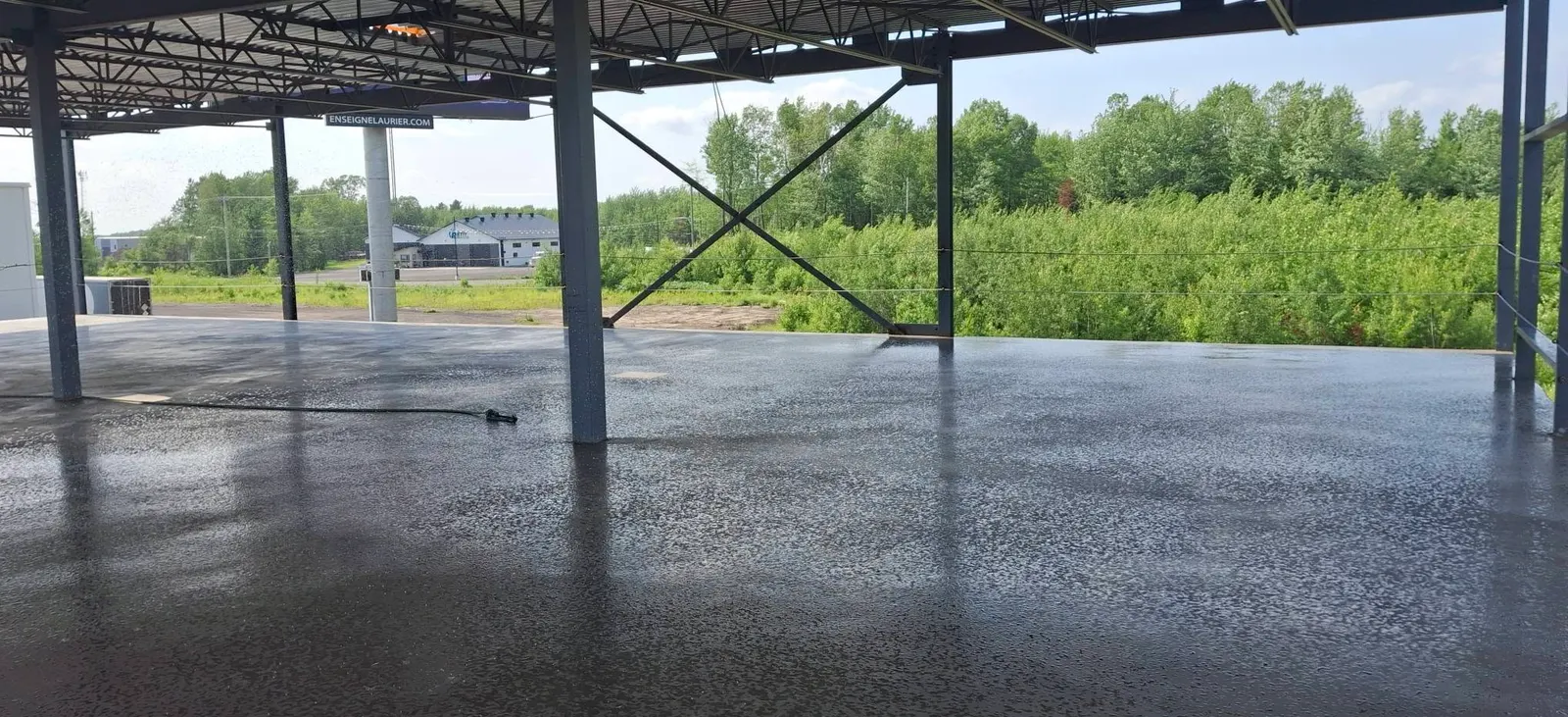 Grande dalle de béton lissée sous la structure en acier d un bâtiment commercial