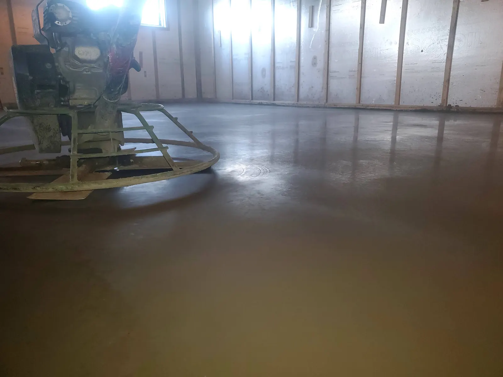 Truelle mécanique sur une dalle de béton intérieure fraîchement lissée