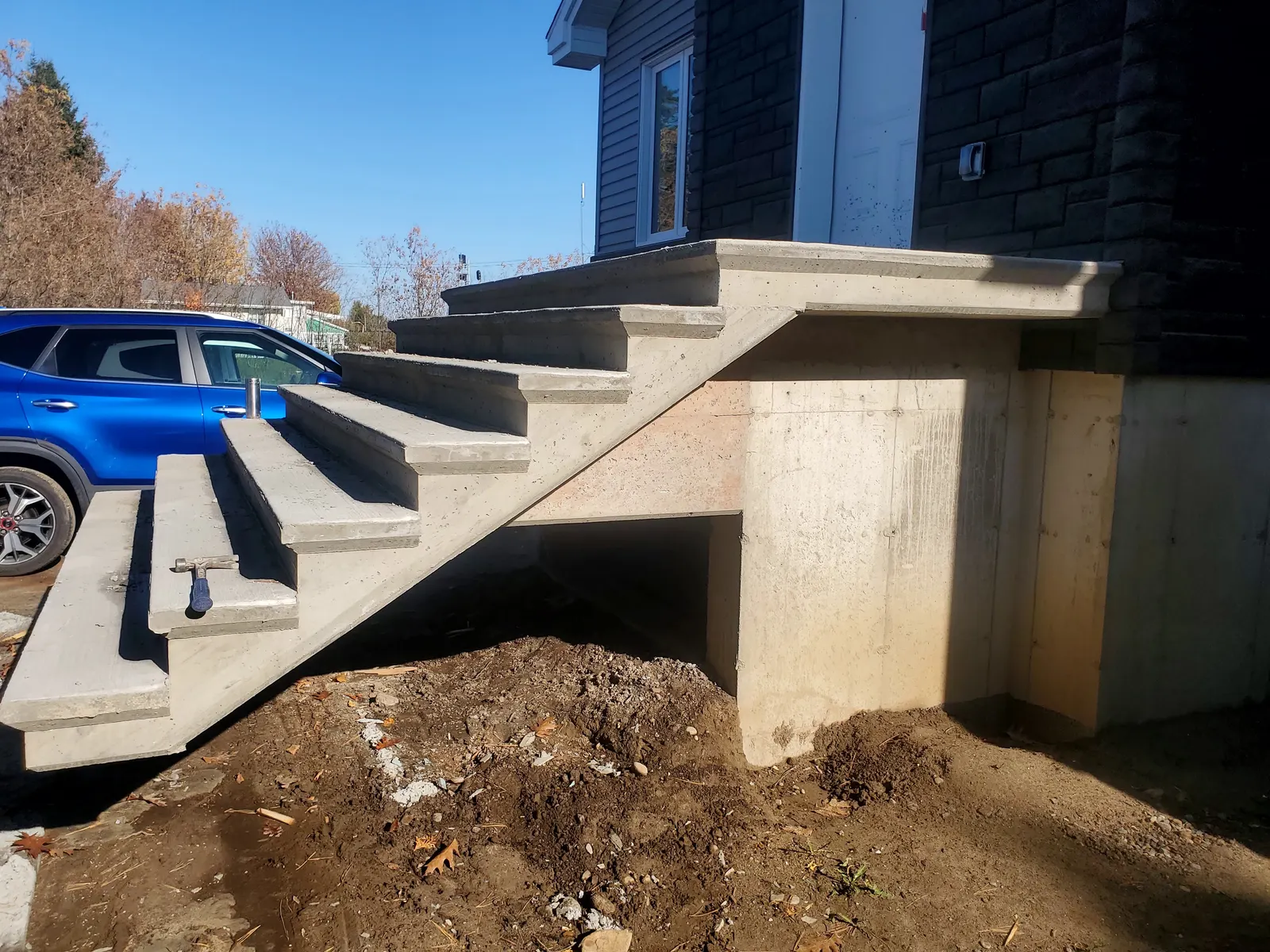 Escalier de béton avec palier devant une maison neuve